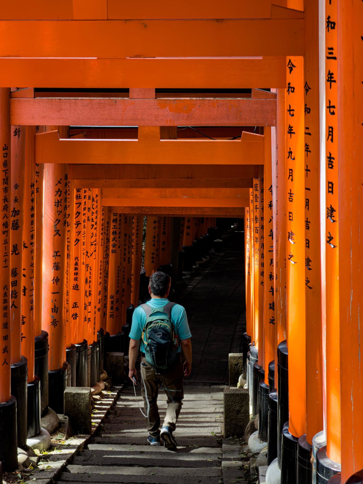 A man walks through the torii gates at Fushimi Inari