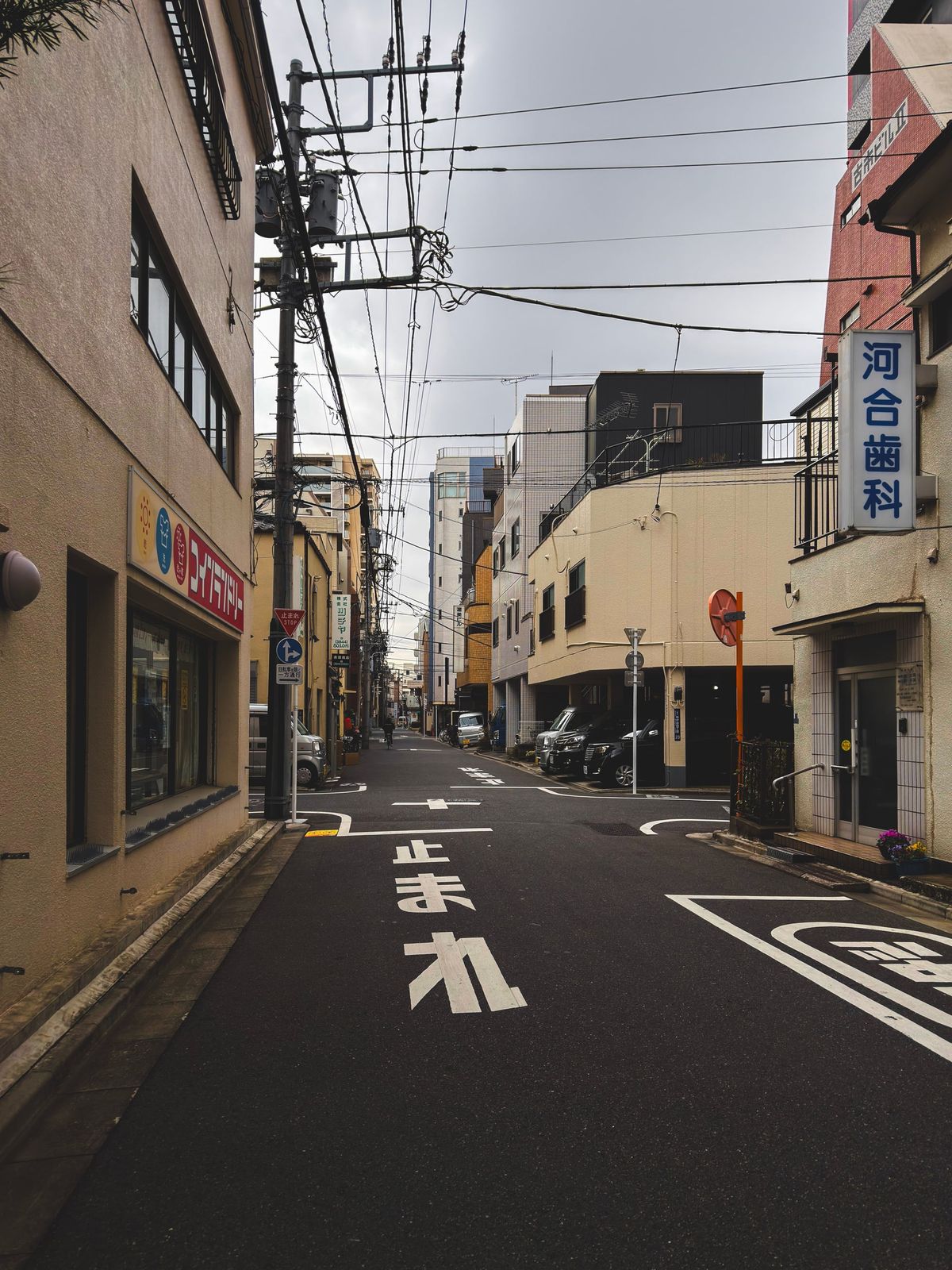 An empty backstreet with a stop sign painted on the road