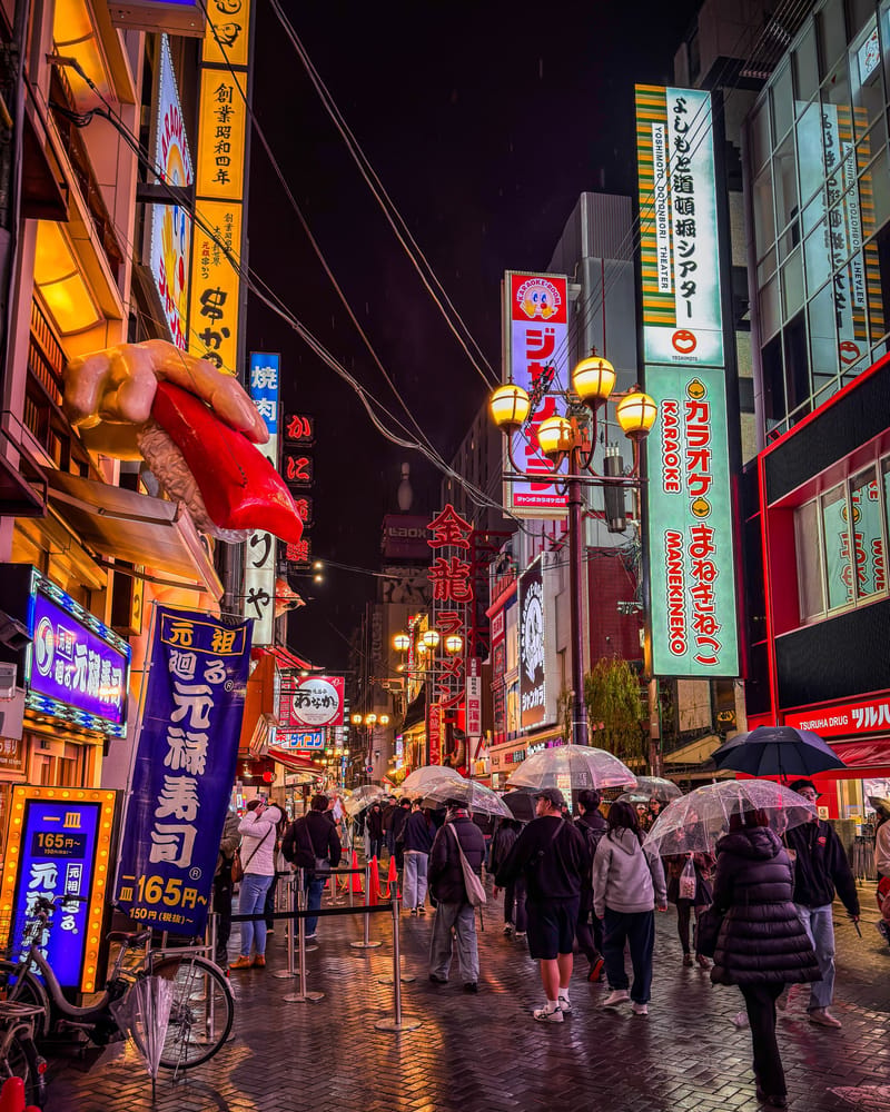 Explore the bustling nightlife of Dotonbori, Osaka with colorful neon lights and rainy atmosphere.